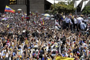 El dirigente opositor y autoproclamado presidente interino de Venezuela, Juan Guaidó, saluda a sus partidarios durante un acto de protesta contra los apagones en Caracas. (AP Foto/Natacha Pisarenko)