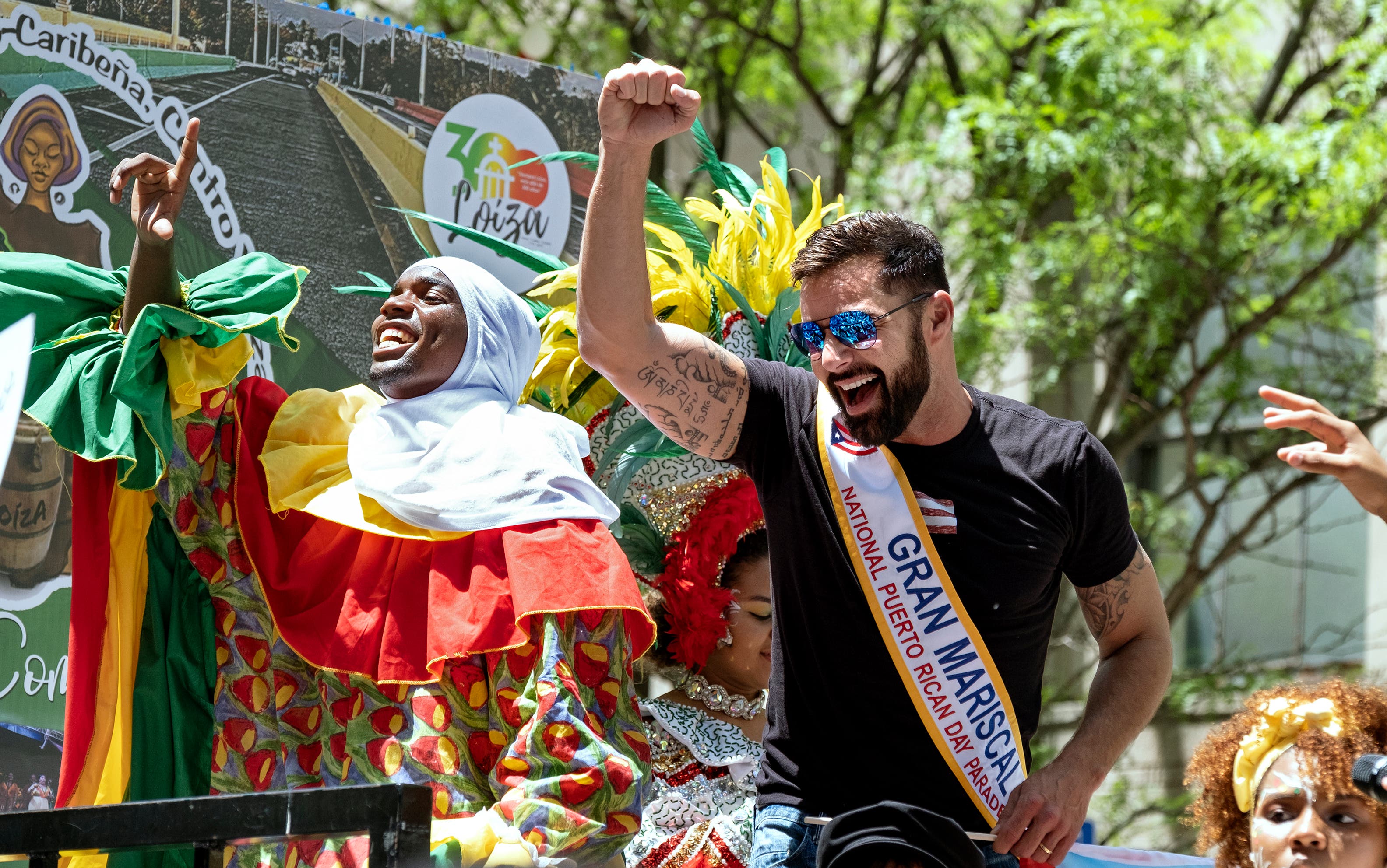 Ricky Martin, a la derecha, gran mariscal del Desfile Nacional del DÃ­a de Puerto Rico, reconoce a los espectadores, el domingo 9 de junio de 2019, en Nueva York.AP