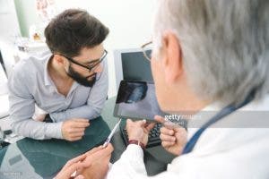 Mature doctor using a digital tablet for his diagnosis.