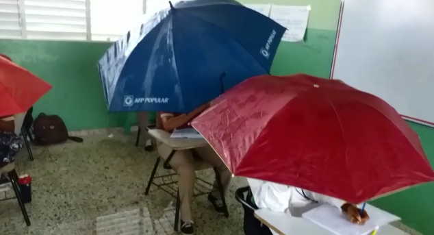 Estudiantes usan sombrillas dentro del aula por filtración en escuela de Bonao