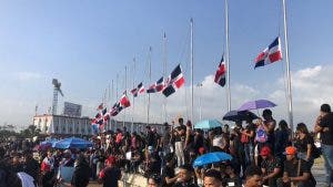 Manifestantes colocan banderas a media asta en la Plaza de la Bandera