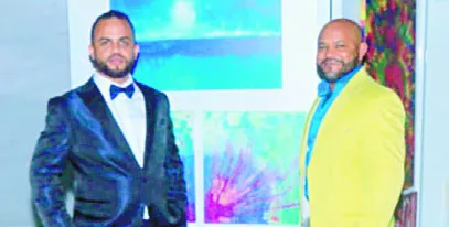 Benjamin Cruz y Luís Heredia  posan frente a obras de Heredia.