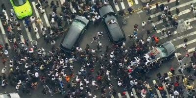 Multitud reunida en Union Square, NY, abruma a policía, salta sobre autos y lanza objetos