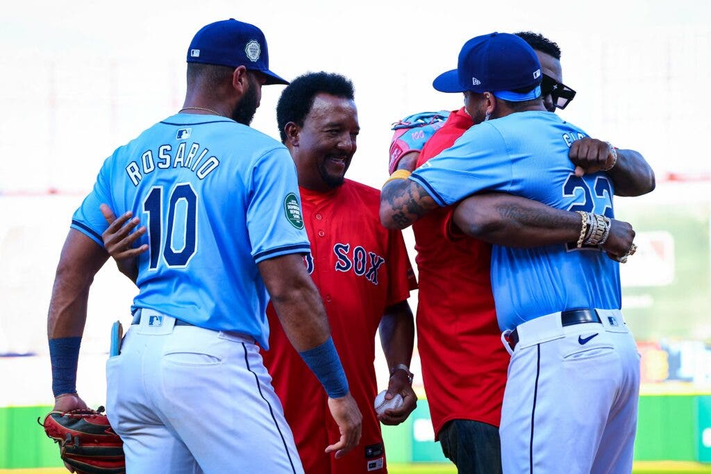 Amed Rosario y José Sirí abrazan a Pedro Martínez y David Ortiz.