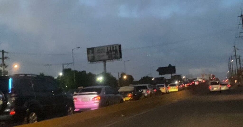 It is barely 6:00 in the morning and the elevated road at the entrance to the Los Alcarrizos municipality is jammed