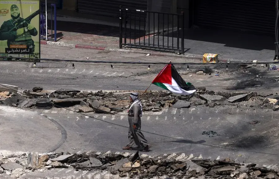 Un palestino ondea una bandera palestina en la ciudad cisjordana de Yenín. EFE/ Alaa Badarneh