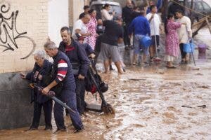 Personas caminan sobre calles inundadas de agua en Valencia. EFE