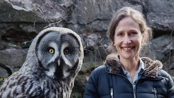 Jennifer Ackerman junto a un gran búho gris (Strix nebulosa).