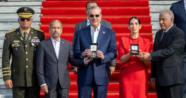 Juan Pablo Uribe entrega la medalla al presidente  Luis Abinader y Raquel Arbaje.