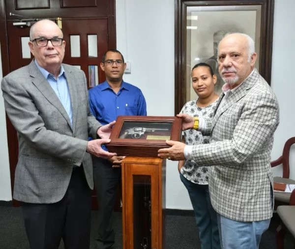 Roberto Cassá recibe  la donación de manos de Manuel Salvador Nadal.