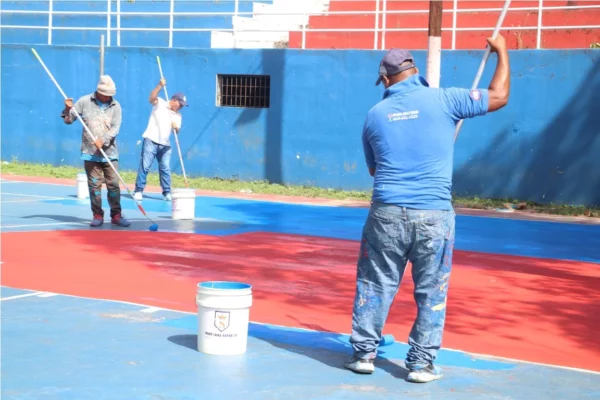 PIE DE FOTO TRABAJADORES DEL INEFI MIENTRAS PINTABAN UNA DE LAS CANCHAS.