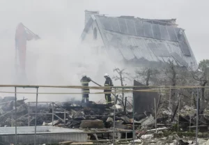 Rescatistas ucranianos trabajan en una zona residencial alcanzada por un cohete ruso cerca de Kiev, en la madrugada del domingo.