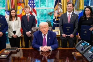 El presidente estadounidense, Donald Trump (C), firma órdenes ejecutivas y habla con los periodistas en el Despacho Oval de la Casa Blanca.