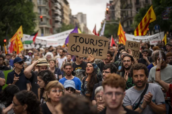 Manifestantes marchan gritando consignas contra el Festival de la Fan de Fórmula 1 en Barcelona, ​​España, el miércoles 19 de junio de 2024, durante la protesta vecinal contra el turismo de masas.