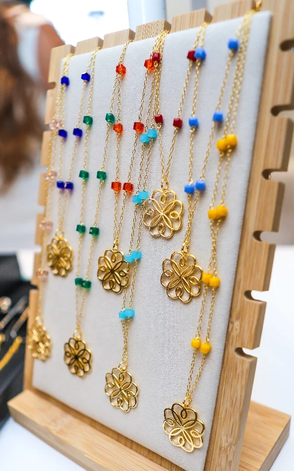 Las piezas incluyen variedad de aretes, cadenas y guillos, cada uno en un color representativo de las fundaciones beneficiarias, junto al collar central que las unifica a todas.