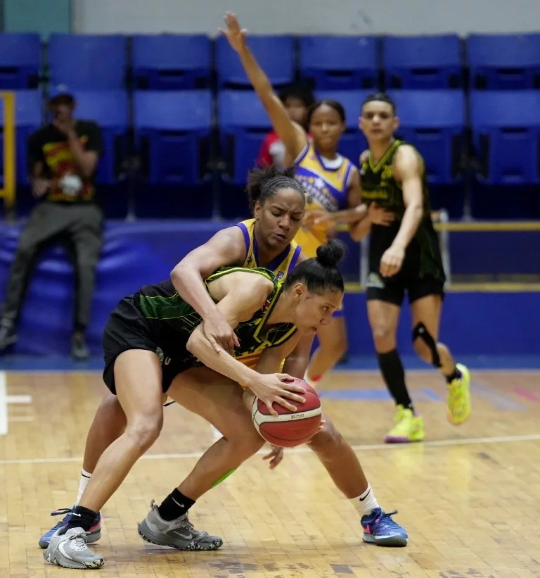Yadira Polanco, del club San Carlos, es fuertemente defendida por Génesis Evangelista, del club Mauricio Báez.
