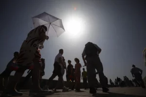 Fotografía de turistas protegiéndose de las altas temperaturas, en Córdoba (España).