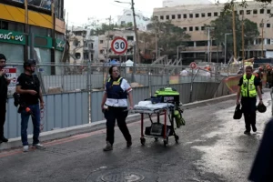 Personal médico israelí se reúne en el lugar donde misiles balísticos iraníes impactaron contra un edificio en Tel Aviv, Israel