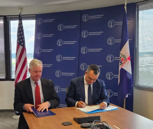 El presidente de la JCE firmando un acuerdo con la OEA