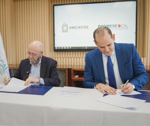 El rector de Unicaribe, Emilio Torres, firma el acuerdo junto al director de PromeseCal, Adolfo Pérez.