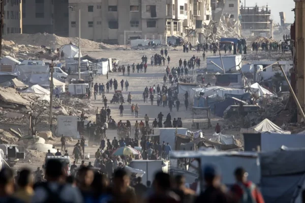 Decenas de palesstinos caminan por un campamento para desplazados en Gaza