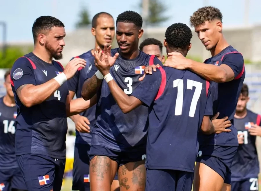 Junior Firpo (centro) rodeado de compañeros durante un partido internacional con la selección dominicana. Archivo