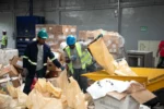Trabajadores manipulan productos decomisados por Pro Consumidor para su destrucción.