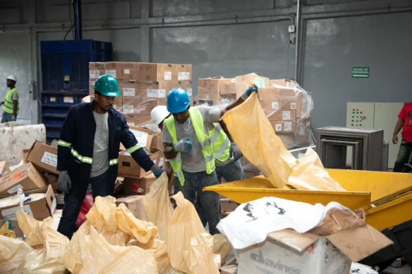 Trabajadores manipulan productos decomisados por Pro Consumidor para su destrucción.