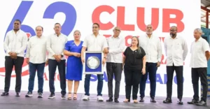 Rafael Uribe recibe su reconocimiento de Gisselle Capellán y Dimitri Mendoza, directivos del club San Lázaro.