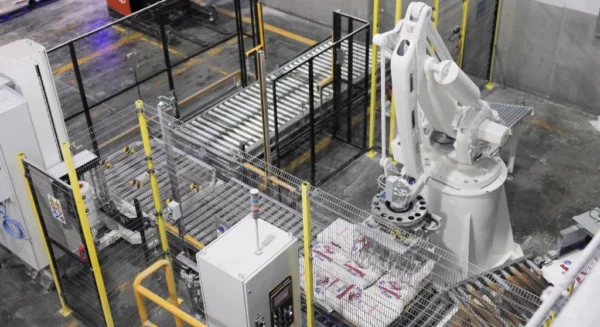 Brazo robótico que optimiza labores logística en empaque de sacos en molino, presentado en recorrido en Molinos del Ozama.