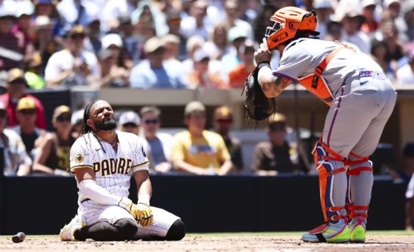 El dominicano Fernando Tatis Jr. de San Diego, se queja de dolor por un pelotazo.  Ap