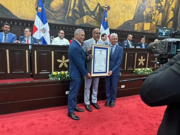 Franklin Romero y Ricardo de los Santos entregan el reconocimiento a Amable Valenzuela