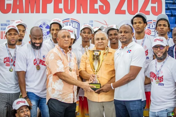 Gilberto De la Cruz, presidente del club Renacer, recibe la copa de campeón de Fernando Geraldino, ejecutivo de Seaboard, y José Mercedes, de la LND U22.