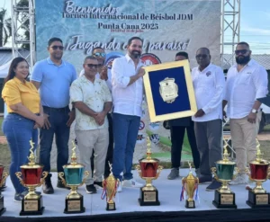 Luis Miñoso, asesor de Comunicaciones del Banco de Reservas, recibe la placa en nombre del presidente del banco, el señor Samuel Pereyra. Entrega José Dijols, presidente del Comité Organizador.