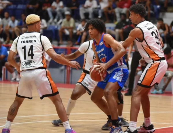 Fénix-Raúl Torres y Yendrí Báez, en los extremos, de los Fénix de Santiago, defienden a Yordi Rodríguez, del CDP de Santiago.