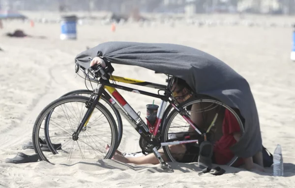 Personas tapándose con una manta en la playa con dos biciletas