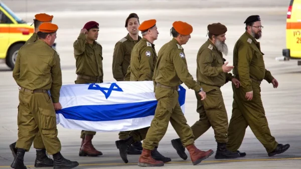 Militares israelíes cargan ataúd de compañero}