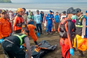 Un equipo de rescate cubre el cadáver de una víctima del naufragio, hallado antes por unos pescadores locales, el 3 de julio de 2025 en una playa de Banyuwangi, en la isla indonesia de Bali, una imagen divulgada por la agencia nacional de emergencias