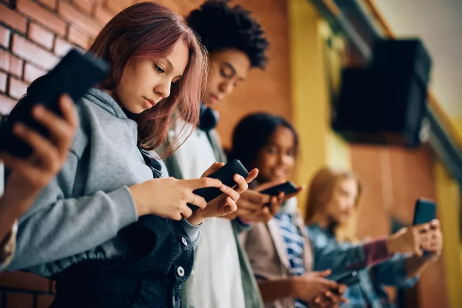 group-of-teenagers-using-mobile-phones-in-hallway-2023-11-27-05-05-30-utc-scaled group-of-teenagers-using-mobile-phones-in-hallway-2023-11-27-05-05-30-utc-scaled