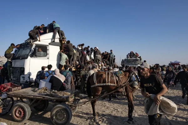 Palestinos suben a camiones de ayuda humanitaria para conseguir comida cerca de un punto de distribución de alimentos en el corredor de Morag, al sur de Jan Yunis (Gaza)