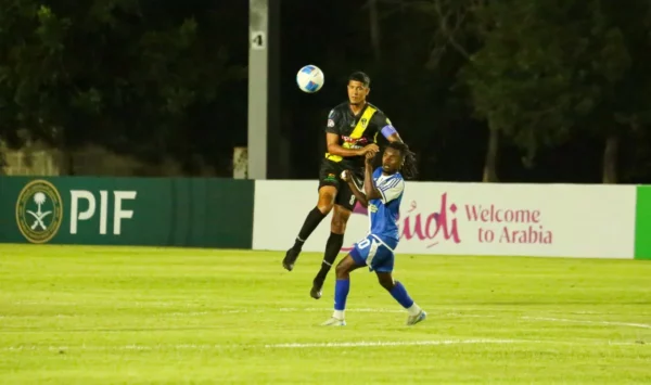 Mount Pleasant-Richard Dabas capitan del MOCA FC despeja un balon con la cabeza ante un defensa del Mount Pleasant FA de Jamaica