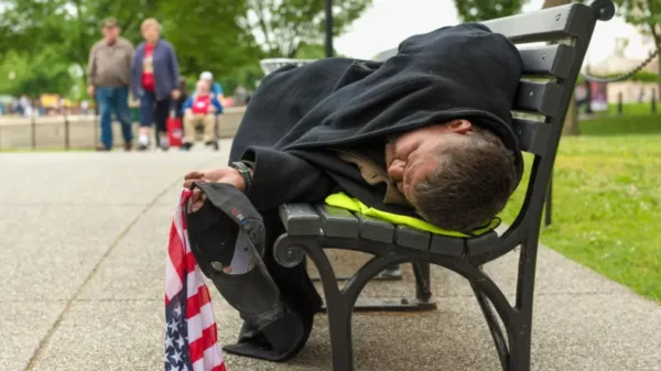 Hombre sin hogar duerme en un parque de Estados Unidos.