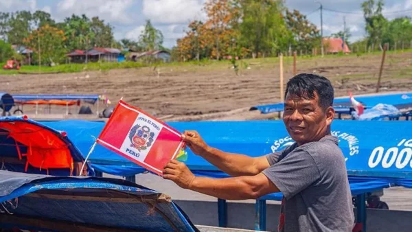 Una persona frente a una lancha cogiendo en las manos una bandera de Perú, en la Isla Santa Rosa este 5 de agosto.