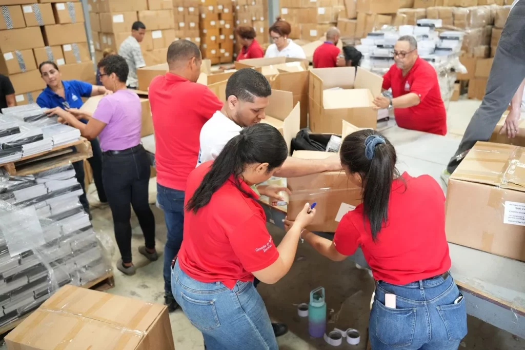 Colaboradores del Inabie trabajan en el despacho de los kits escolares para las escuelas públicas.