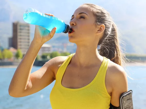 Mujer bebe electrolitos después de entrenar
