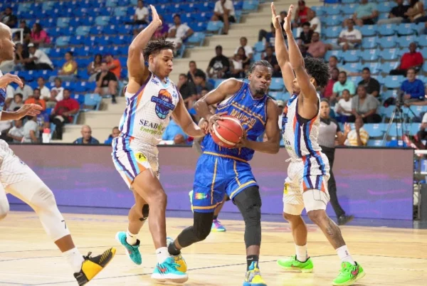 Juan Miguel Suero, del   Mauricio Báez, realiza una  ofensiva.