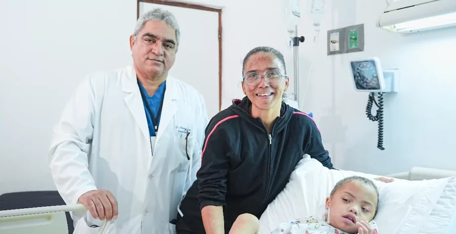 Cirujano cardiovascular Ramón Almánzar junto a un infante y su madre. Cirujano cardiovascular Ramón Almánzar junto a un infante y su madre.