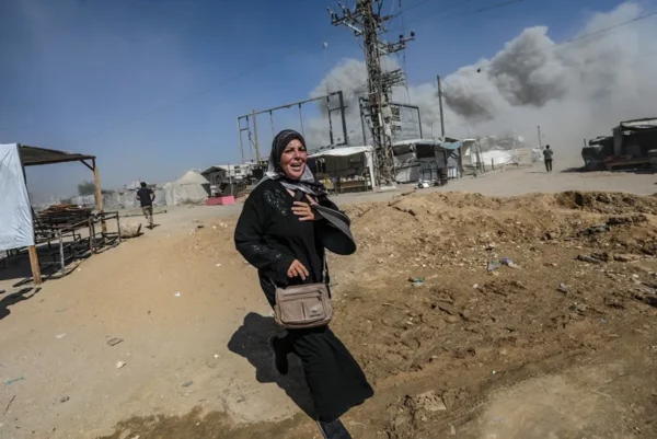 Una mujer palestina corre a refugiarse tras un ataque aéreo israelí este lunes en el oeste de la Ciudad de Gaza.