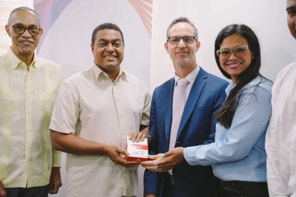 José P. Monegro, presidente del Comité Organizador y Francisco León, director de la Oficina Regional de América Latina y el Caribe de la Agencia Mundial Antidopaje (WADA, sostienen un kit antidopaje que se utilizará para los Juegos Centroamericanos y del Caribe Santo Domingo 2026. Figura, el doctor Milton Pinedo (izquierda) entre otro.