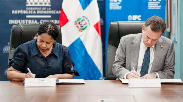 Ronke Ogunsulire, representante de IFC, y el ministro  Víctor Bisonón  firmando el convenio.